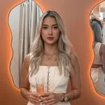 Giovana Santiago diante de um espelho orgânico iluminado